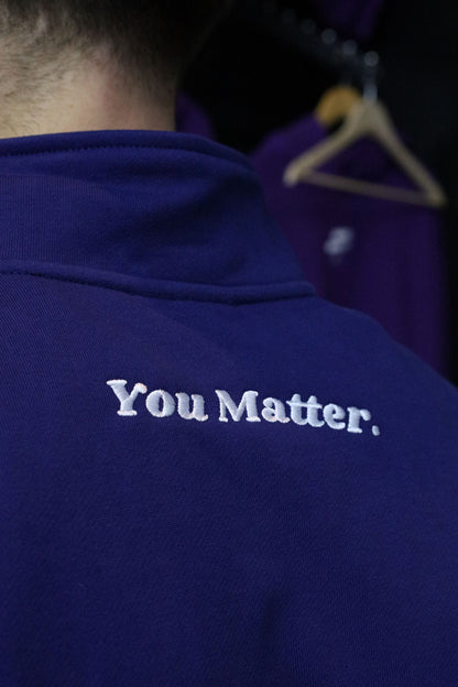 You Matter embroidery on the back of navy quarter-zip